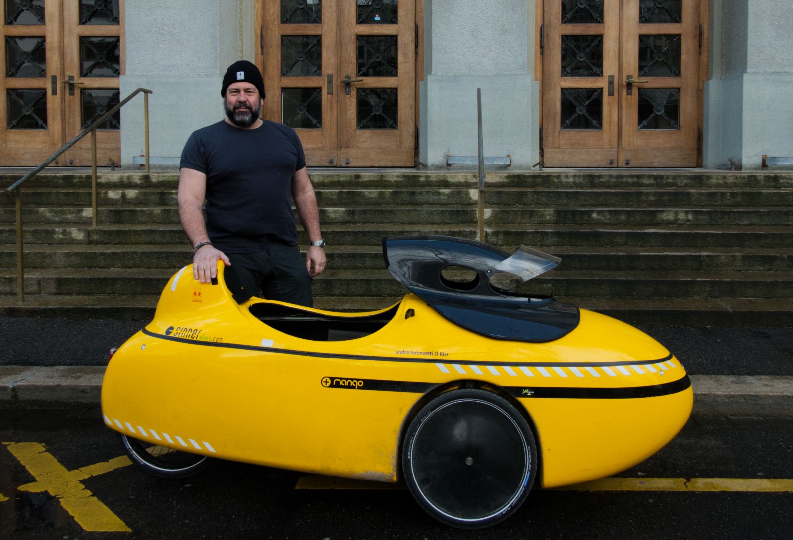 Titelbild 1: André Lorenzetti mit seinem Liegevelo vor einem Eingang des Gymnasiums Kirchenfeld; Foto: Melinda Widler